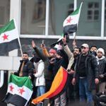 Menschen schwenken syrische Flaggen