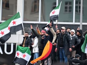 Menschen schwenken syrische Flaggen