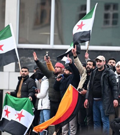 Menschen schwenken syrische Flaggen