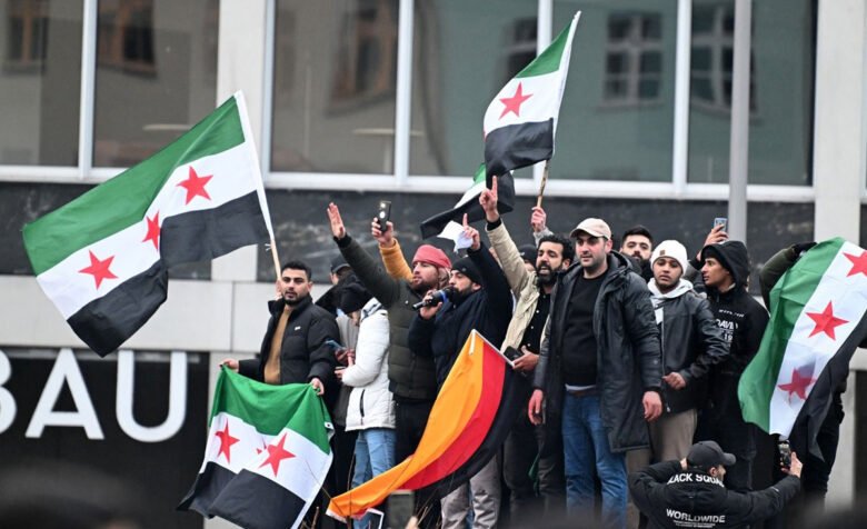Menschen schwenken syrische Flaggen